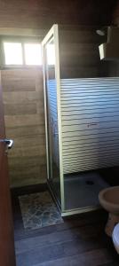 a bathroom with a shower with a sliding glass door at Casita en el río, Mayu Sumaj in San Antonio de Arredondo