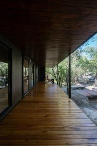 a wooden boardwalk leading to a house with windows at Casita en el río, Mayu Sumaj in San Antonio de Arredondo