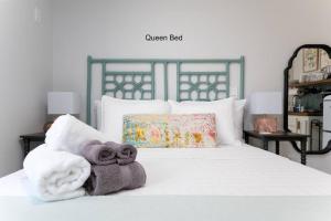 a bedroom with a white bed with towels on it at Be A Nomad - Jacksonville Beach Studio - 60-Second Walk to Ocean - Sleeps 2 in Jacksonville Beach