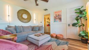 a living room with a couch and a mirror at 5 mins to Speedway! Walk to Zoo, WR park, IUPUI! in Indianapolis