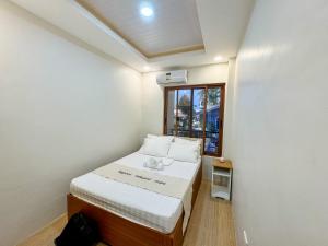 a small room with a bed and a window at Happynest Rooms in Santa Fe Bantayan Island in Pooc