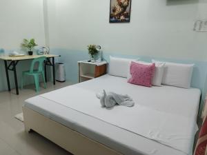 uma grande cama branca num quarto com uma mesa em Ocean View Lodging House em Oslob