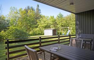a table and chairs on a deck with a grill at Beautiful Home In Toftlund With Wifi in Toftlund +7 photos