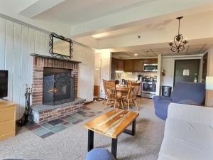 a living room with a fireplace and a table at LilBear- AC, Pool, Sauna, Hot Tub, Near Resort in Killington