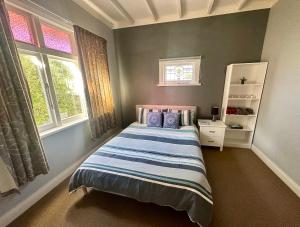北帕默斯頓的住宿－RS Two-Bedroom Apartment，一间卧室设有一张床和两个窗户。