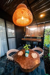 Una mesa de madera con sillas y una mesa con una planta encima. en Villas Mundi, en La Tebaida
