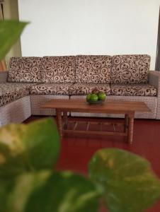 ein Sofa und einen Tisch mit einer Schale Obst drauf in der Unterkunft Dishari Homestay Tangalle in Tangalle