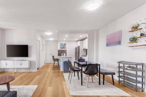 MerrylandsModern Luxury 3 Bedrm Apt Close to Parramatta, CBD的带桌椅和电视的客厅