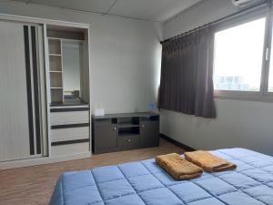 een slaapkamer met een bed met twee handdoeken erop bij Solitude Skies14th Floor Studio in Nonthaburi