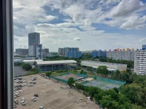 een uitzicht op een parkeerplaats met een tennisbaan bij Solitude Skies14th Floor Studio in Nonthaburi
