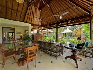 ein offenes Esszimmer mit einem Tisch und Stühlen in der Unterkunft Villa Kedidi in Canggu