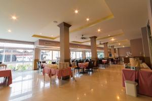 a restaurant with tables and chairs in a room at SinKiat Buri Hotel in Satun