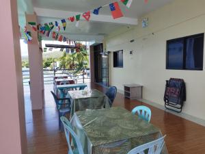uma sala de jantar com mesas, cadeiras e bandeiras em Ocean View Lodging House em Oslob