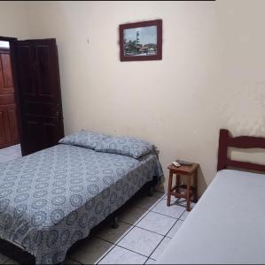 巴雷里尼亚斯Pousada Tia Cota的一间卧室，有两张床，墙上挂着一幅画