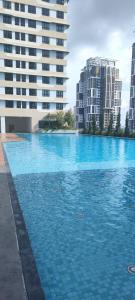 a large pool of blue water with tall buildings at DETA Edusphere Cyberjaya in Cyberjaya