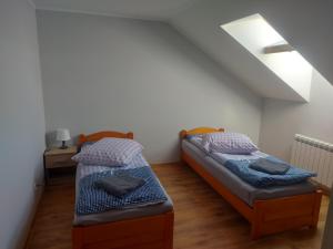 two beds in a room with a attic at DAR-KAJ MIESZKANIE nr 2 in Radzyń Chełmiński