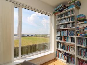 una ventana en una habitación con estanterías en Jurassic Coast House, en Portland
