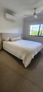 a large bed in a bedroom with a large window at Starfish Beach House in Agnes Water