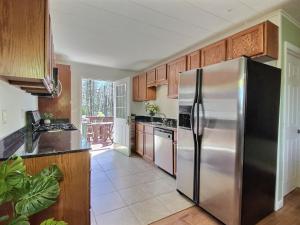 キリングトンにあるDoubleDen- AC, Hot Tub, Fire pit, Grill, Game Roomのキッチン(ステンレス製の冷蔵庫、木製キャビネット付)