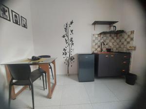 a kitchen with a table and a table and a refrigerator at Kitnet Vila Marcela 1 in Petrolina