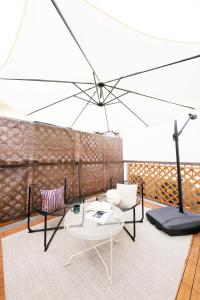 a living room with a table and chairs and an umbrella at City Hotel Osaka Retreat in Osaka