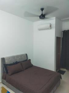a bedroom with a bed and a ceiling fan at Dkyra homestay teluk kemang in Port Dickson