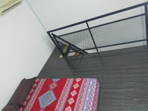 a stair case with a metal railing and a rug at Dkyra homestay teluk kemang in Port Dickson