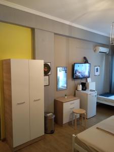 a living room with a tv and a bed at Acropolis Ermou Rooms at Plaka in Athens