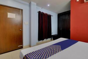 SPOT ON Hotel C S Tower في لاكناو: غرفة نوم بسرير وخزانة وباب