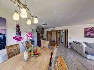 a dining room and living room with a table and chairs at Uitzicht op het meer - formerly TUI in Schalkenmehren