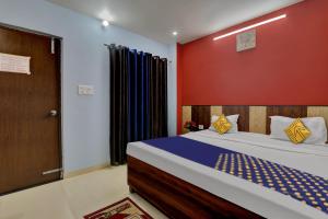 een slaapkamer met een bed en een rode muur bij SPOT ON Hotel C S Tower in Lucknow