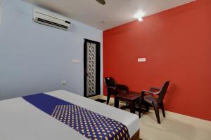 een slaapkamer met een bed en een tafel en stoelen bij SPOT ON Hotel C S Tower in Lucknow