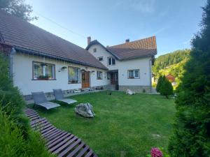 einen Hof mit zwei Stühlen und einem Haus in der Unterkunft Casa Ioana in Poiana Mărului