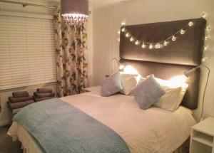 a bedroom with a large bed with lights on it at Avon Wood in Lake Side