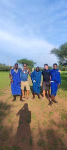 a group of men dressed in blue posing for a picture at SURUNGAI EMANYATA Maasai Boma in Arusha