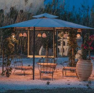 uma mesa e cadeiras debaixo de um guarda-sol azul em Archetypo Villas and Suites em Naxos Chora
