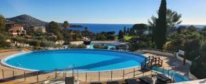 a large swimming pool with a view of the ocean at Cap Esterel, Duplex ,Vue Mer Climatisé in Agay - Saint Raphael