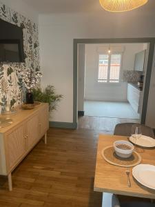 a living room with a dining table and a tv at Appartement calais nord in Calais