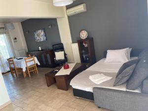 a bedroom with a bed and a couch and a table at Mesaria House Syros in Ermoupoli