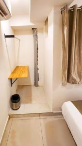 a small room with a bed and a wooden table at Hotel Nova Shine in Rajkot