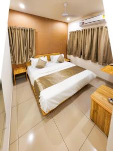 a bedroom with a large bed in a room at Hotel Nova Shine in Rajkot