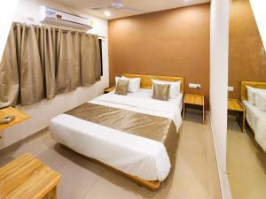 a bedroom with a large bed and a window at Hotel Nova Shine in Rajkot