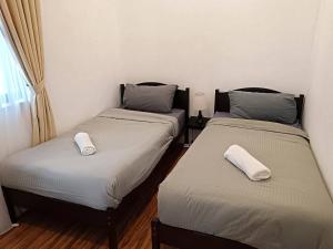 2 camas en una habitación con almohadas blancas. en Near Legoland-Sophisticated Home #Cowidea, en Nusajaya