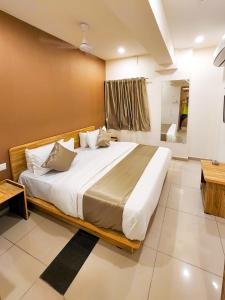 a bedroom with a large bed in a room at Hotel Nova Shine in Rajkot