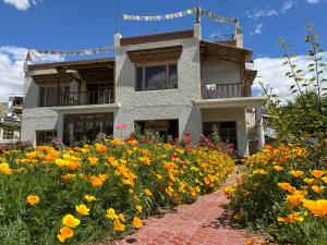 a house with a garden of flowers in front of it at Chakzot garden house in Leh