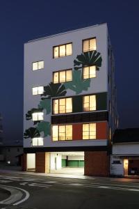 熊本市にあるゲストハウス　ティガの夜間の照明付き窓のある高層ビル