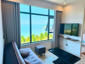 a living room with a couch and a large window at Sunset Apartments Seaview in Nha Trang