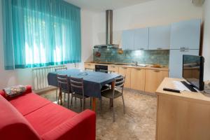 a kitchen with a table and a red couch at Magnani Appartamenti in Misano Adriatico +35 photos
