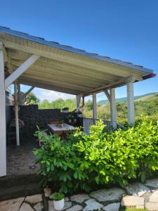 a patio with a roof on top of some bushes at Cottage House in Pača