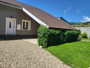 a house with a white door and a green hedge at Cottage House in Pača
